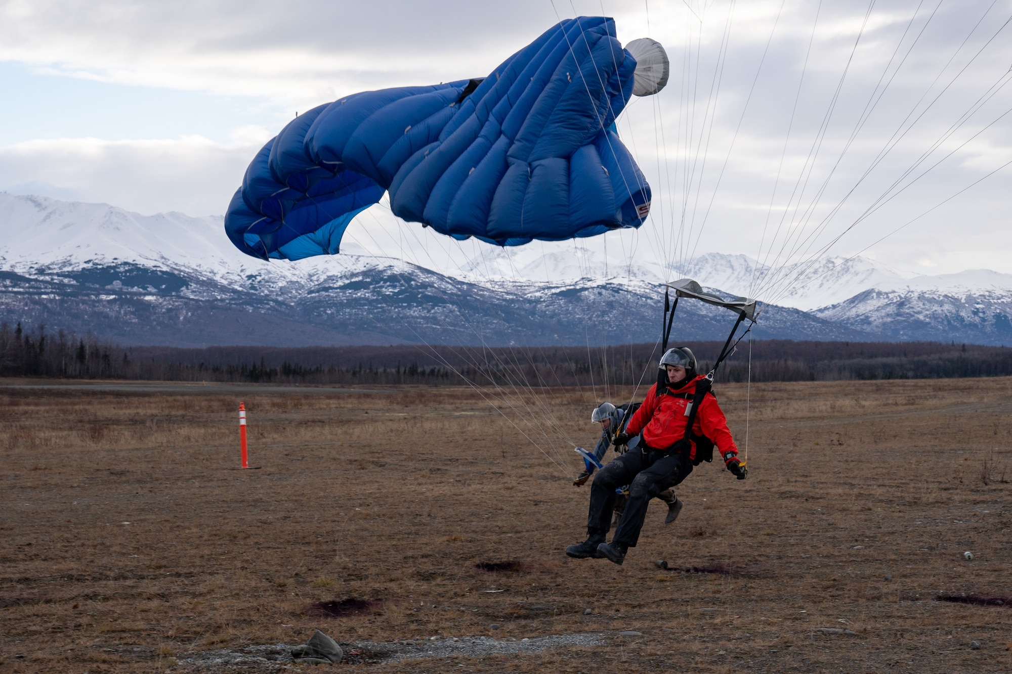 U.S. Air Force Master Sgt. Chris Bowerfind glides past Master Sgt. Nick Watson, both pararescuemen assigned to the 212th Rescue Squadron, Alaska Air National Guard, to land directly on target during a training event at Joint Base Elmendorf-Richardson.