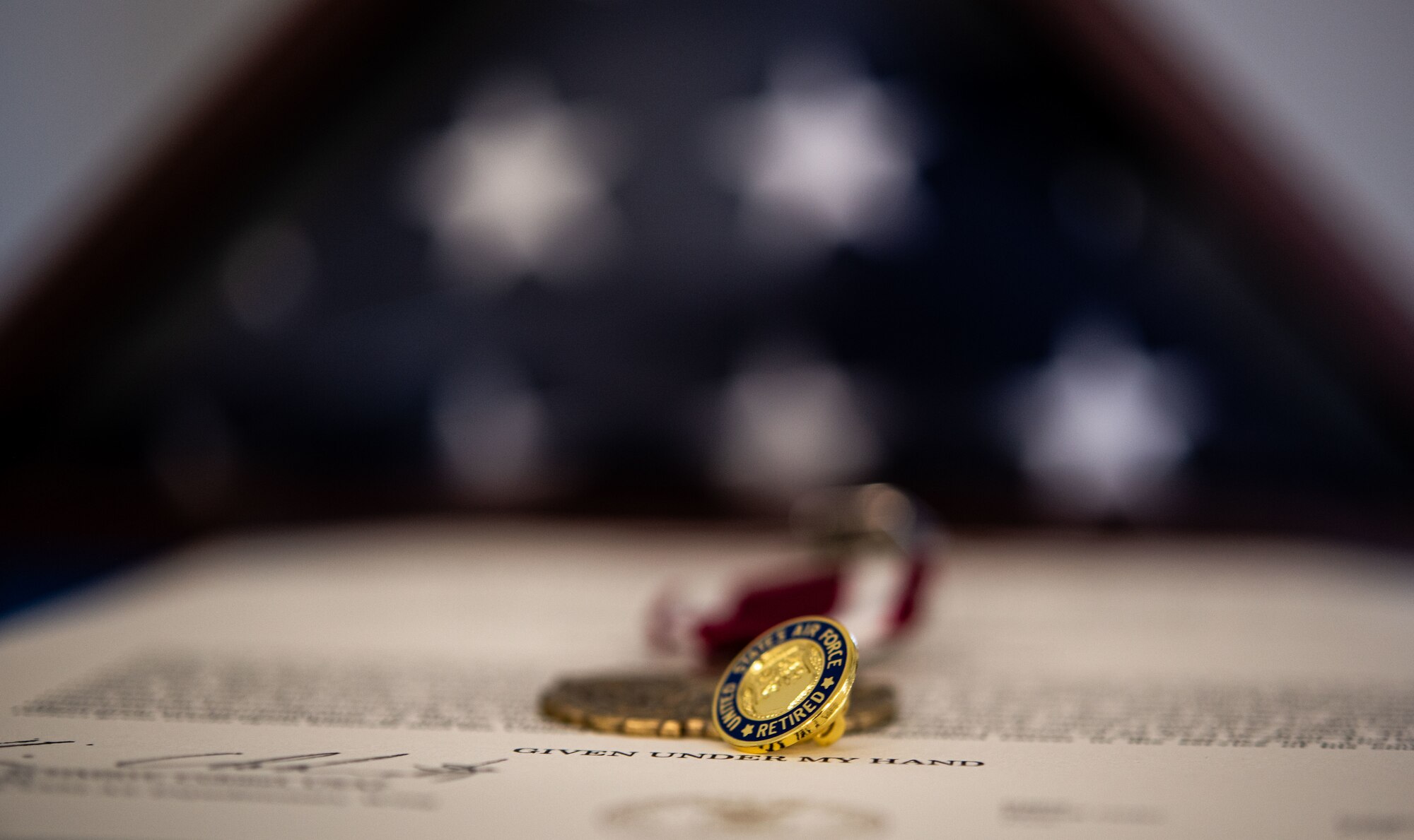 A U.S. Air Force retiree pin rests on top of a decoration at a retirement ceremony.