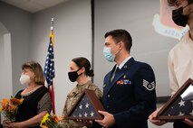 Staff Sgt. Ethan Mendenhall holds a folded flag during his father's retirement ceremony.