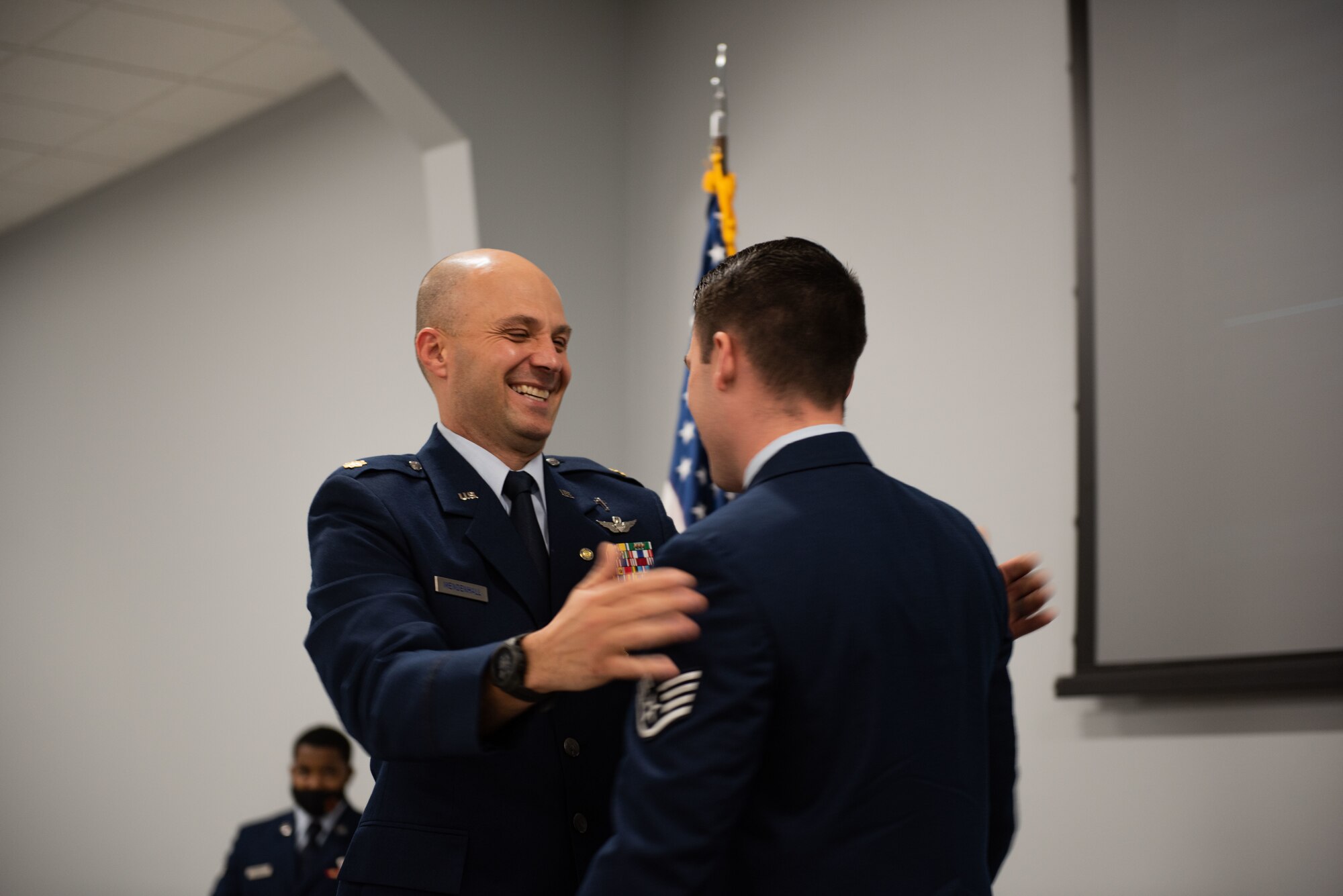 Maj. Matthew Mendenhall congratulates his son, Staff Sgt. Ethan Mendenhall after his re-enlistment in the U.S. Air Force.