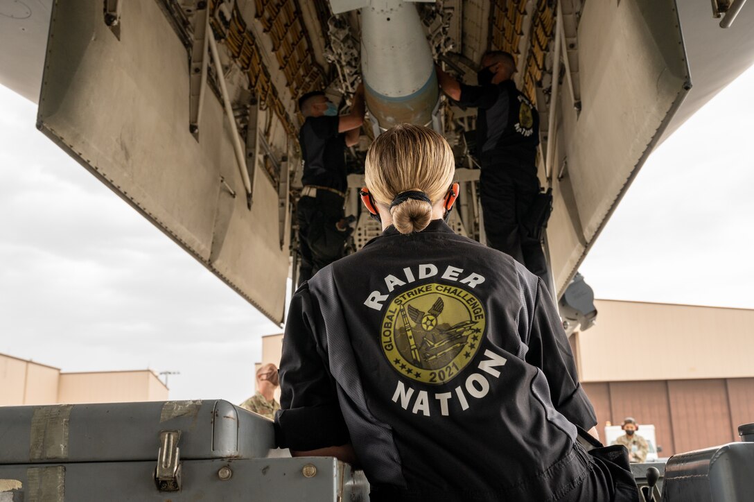 Airman 1st Class Sayge Collopy, 34th Aircraft Maintenance Unit load crew member, watches  as two of her teammates load munitions into a B1-B Lancer at Ellsworth Air Force Base, S.D., Sept. 13, 2021. The crew was tasked with competing against all the other bases in Global Strike Command for loading weapons as efficiently and quickly as possible. (U.S. Air Force photo by Senior Airman Michael Ward)