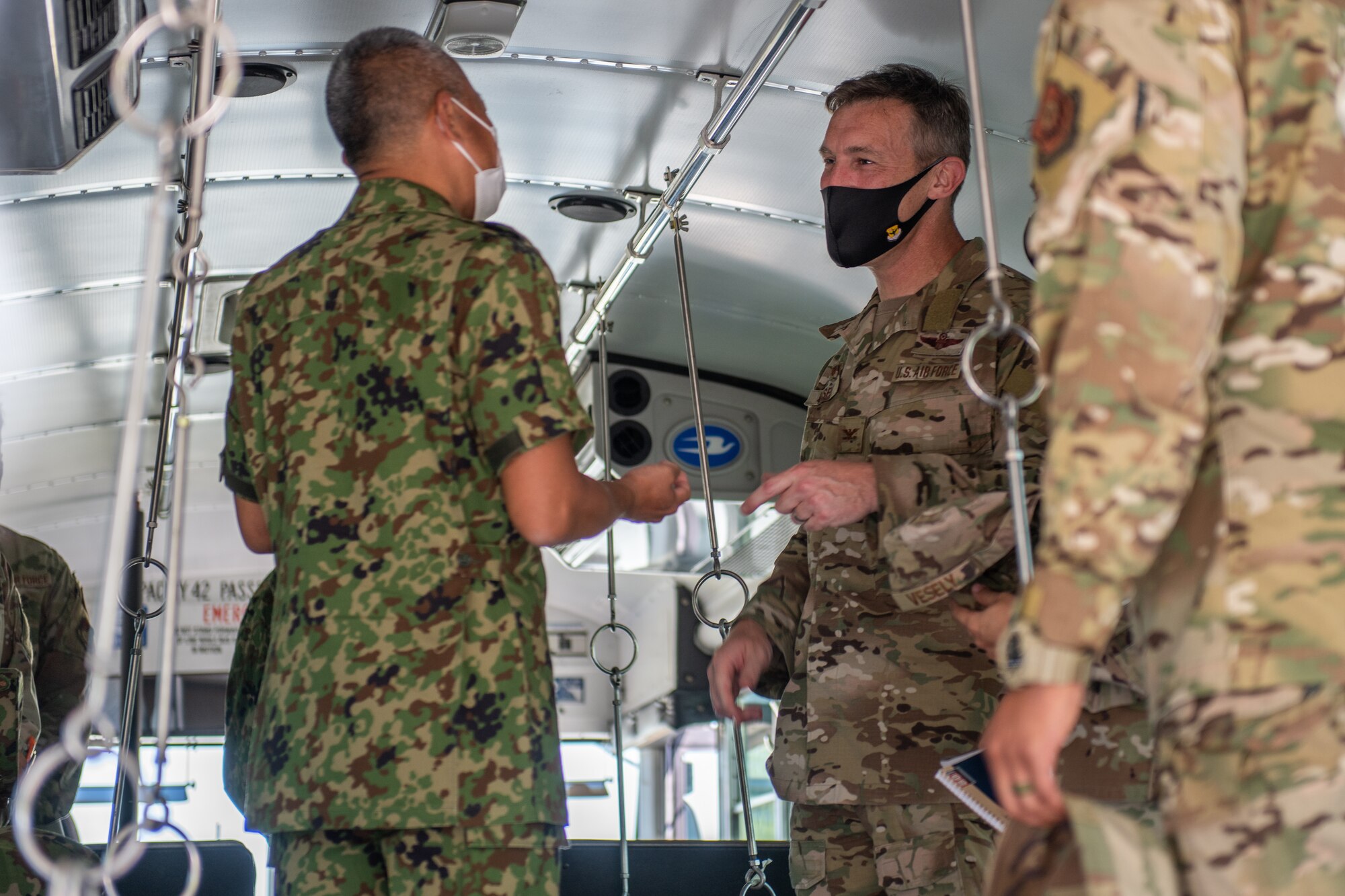 A Japanese military member thanks an American military member for a gift