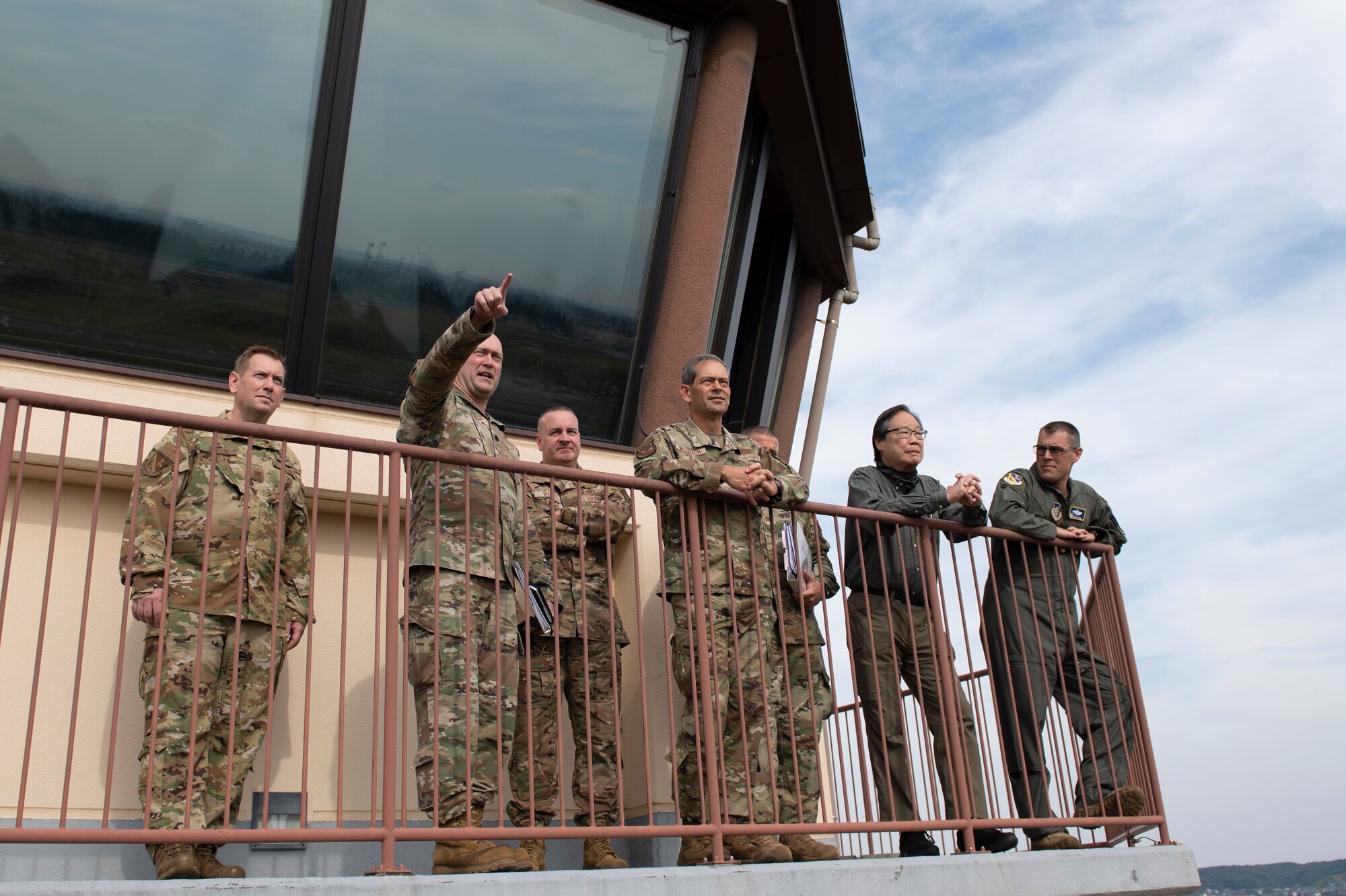 Several high ranking Pacific Air Forces officials stand at the top of the base Flight Control Tower discussing construction plans.