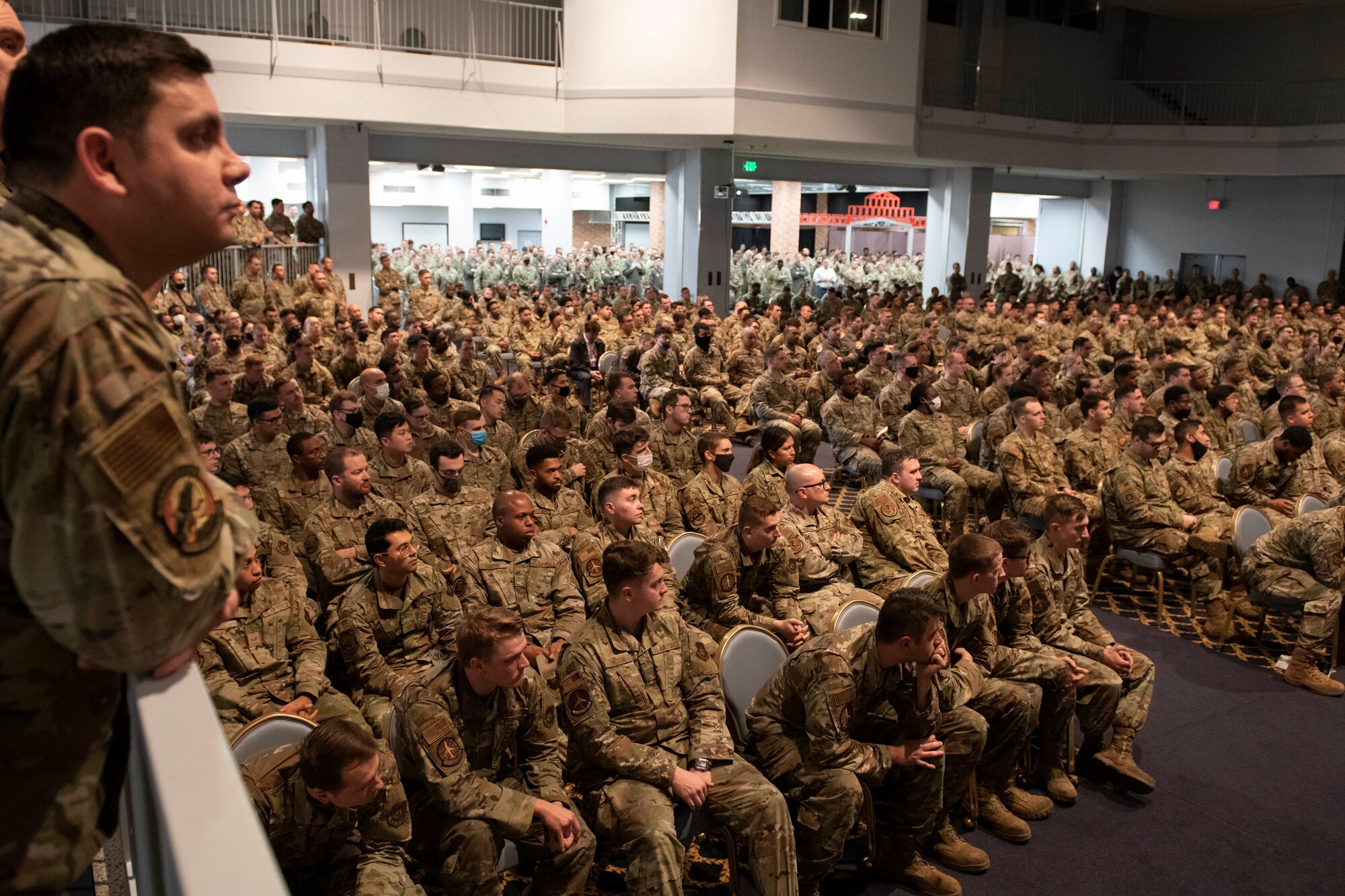 Hundreds of UASF Airmen seated in a large auditorium listen to a visiting General.
