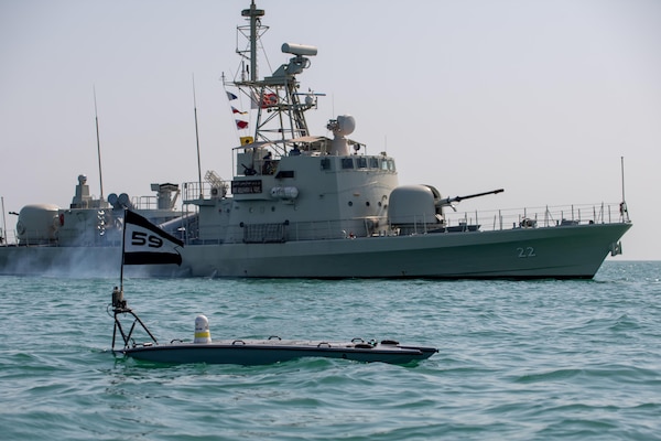 An unmanned vessel floats in front of a ship.