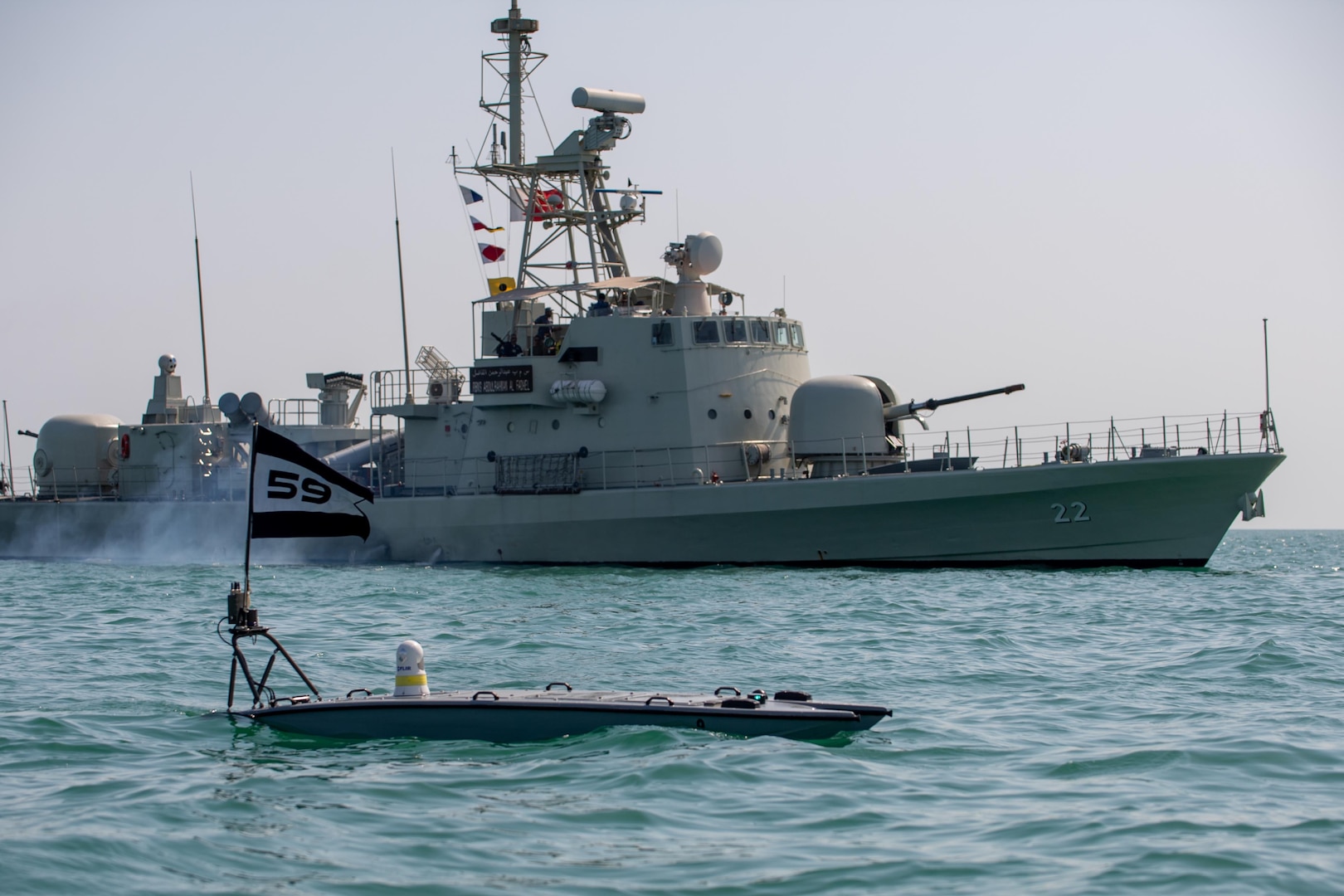 An unmanned vessel floats in front of a ship.