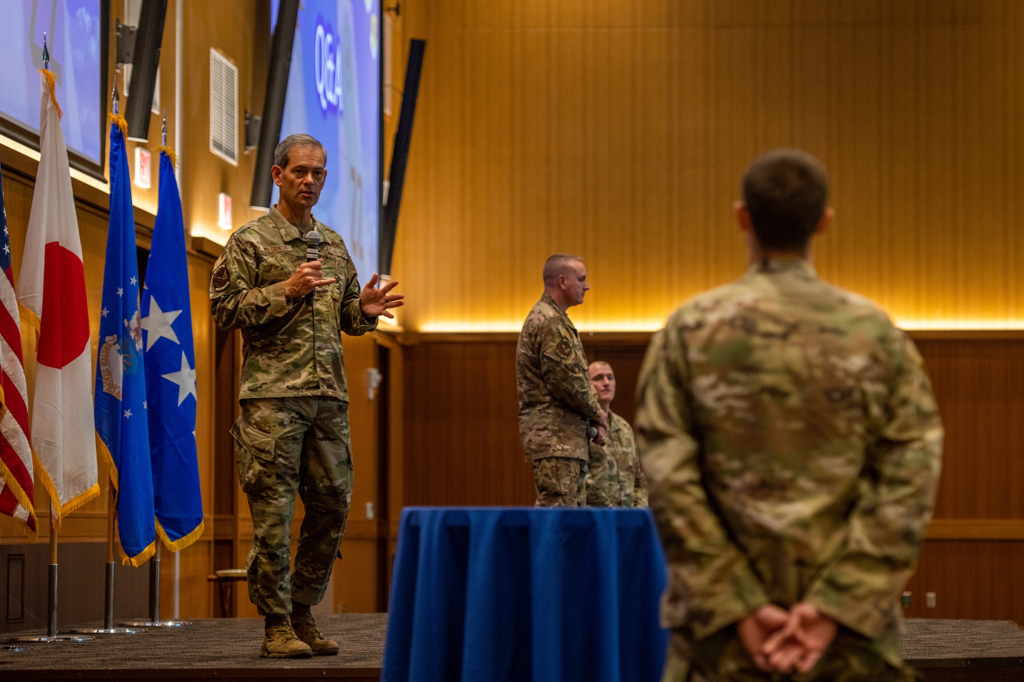 A General responds to an Airman who posed a question during his talk