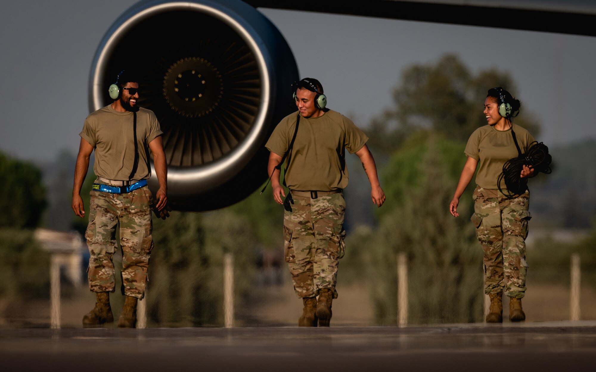 U.S. Air Force crew chiefs walk down the flight line following a refueling operation as part of an Agile Combat Employment training event