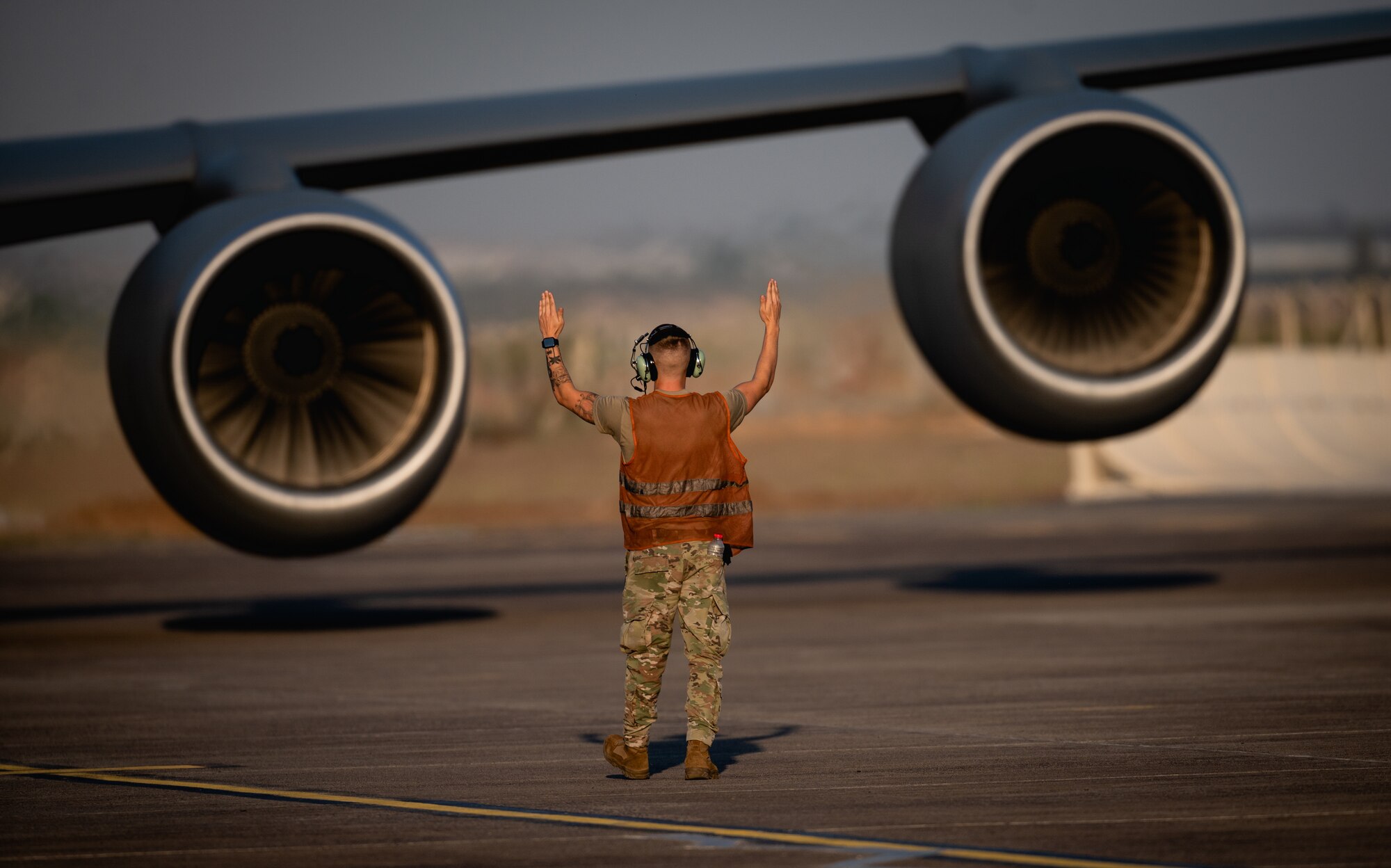 U.S. Air Force crew chief marshals a KC-135 Stratotanker during a refueling operation