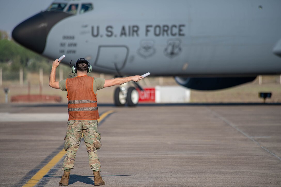 U.S. Air Force crew chief marshals a KC-135 Stratotanker