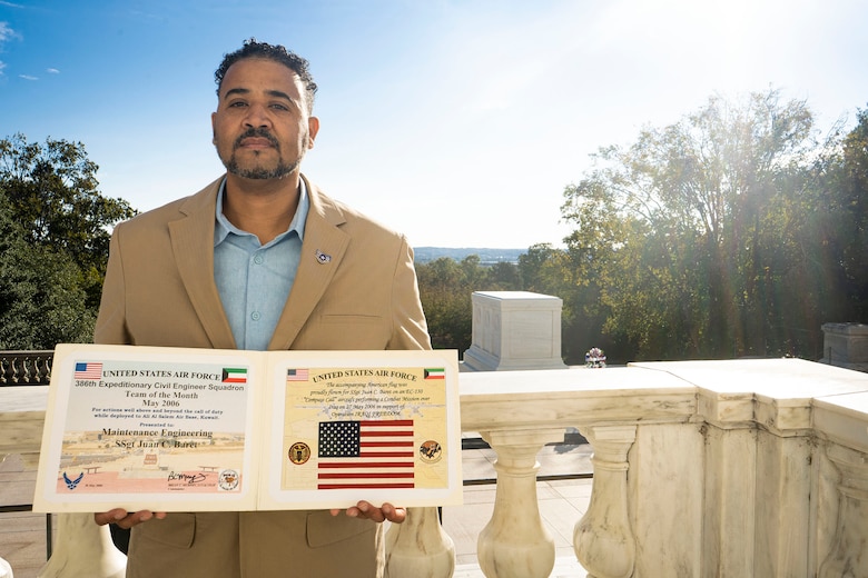U.S. Air Force Veteran Juan Baret, U.S. Army Corps of Engineers, Baltimore District, engineering technician, holds an Operation IRAQI FREEDOM expeditionary team award during a Veteran’s Day tribute at the Arlington National Cemetery’s Tomb of the Unknown Soldier in Arlington, Va., Oct. 22, 2021. In remarks made during the establishment of the Tomb in March 1921, Rep. Hamilton Fish III stated, “The burial of the Unknown Warrior should give the whole country an opportunity to express in a National way, their tribute to the glorious dead.” (U.S. Army photo by Greg Nash)