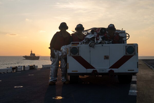 EAST CHINA SEA (Nov. 3, 2021) Sailors assigned to the forward-deployed amphibious assault ship USS America (LHA 6) stand fire watch on the flight deck while the ship sails in formation with the Japan Maritime Self-Defense Force ship JS Ise (DDH 182). America, lead ship of the America Amphibious Ready Group, is operating in the U.S. 7th Fleet area of responsibility to enhance interoperability with allies and partners and serve as a ready response force to defend peace and stability in the Indo-Pacific region. (U.S. Navy photo by Mass Communication Specialist 2nd Class Shelby Tucker)