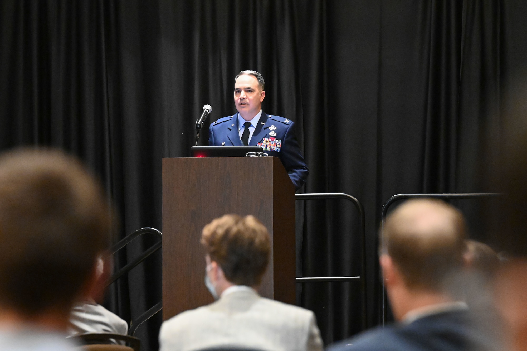 Air Force colonel speaks to a group of civilians at a meeting.