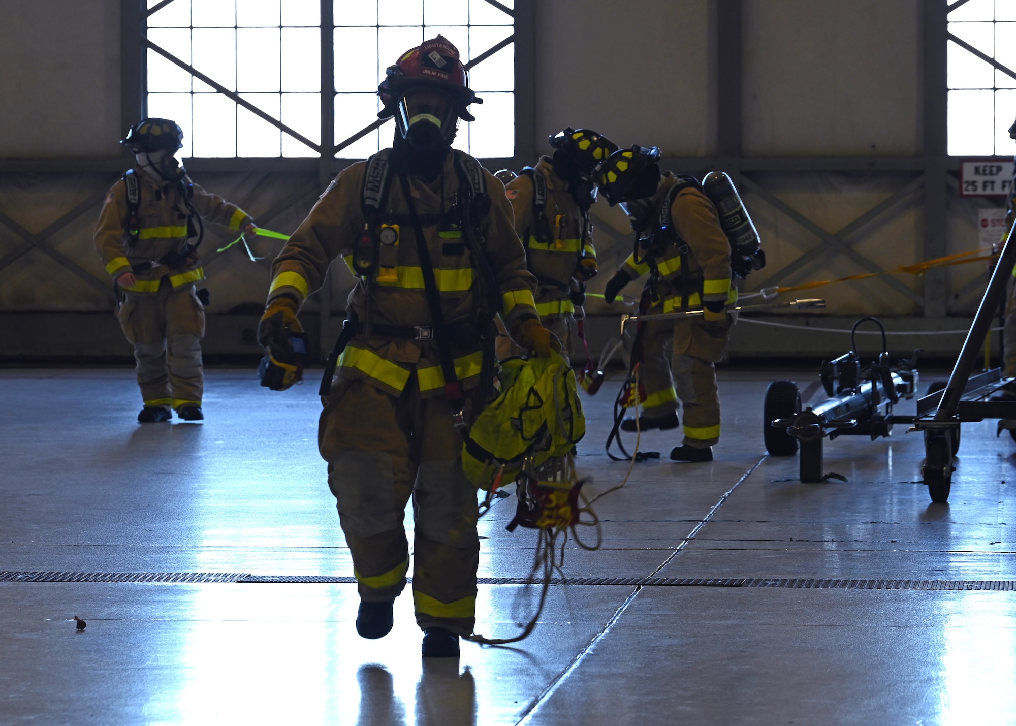 Lewis-McChord Fire and Emergency Services emergency responders participate in a simulated emergency at a hangar during Exercise Rainier War 21B at Joint Base Lewis-McChord, Washington, Nov. 8, 2021. Rainier War is a semi-annual, large readiness exercise led by 62nd Airlift Wing, designed to train Airmen under realistic scenarios that support a full spectrum readiness operations against modern threats and replicate today’s contingency operations.  (U.S. Air Force photo by Senior Airman Zoe Thacker)