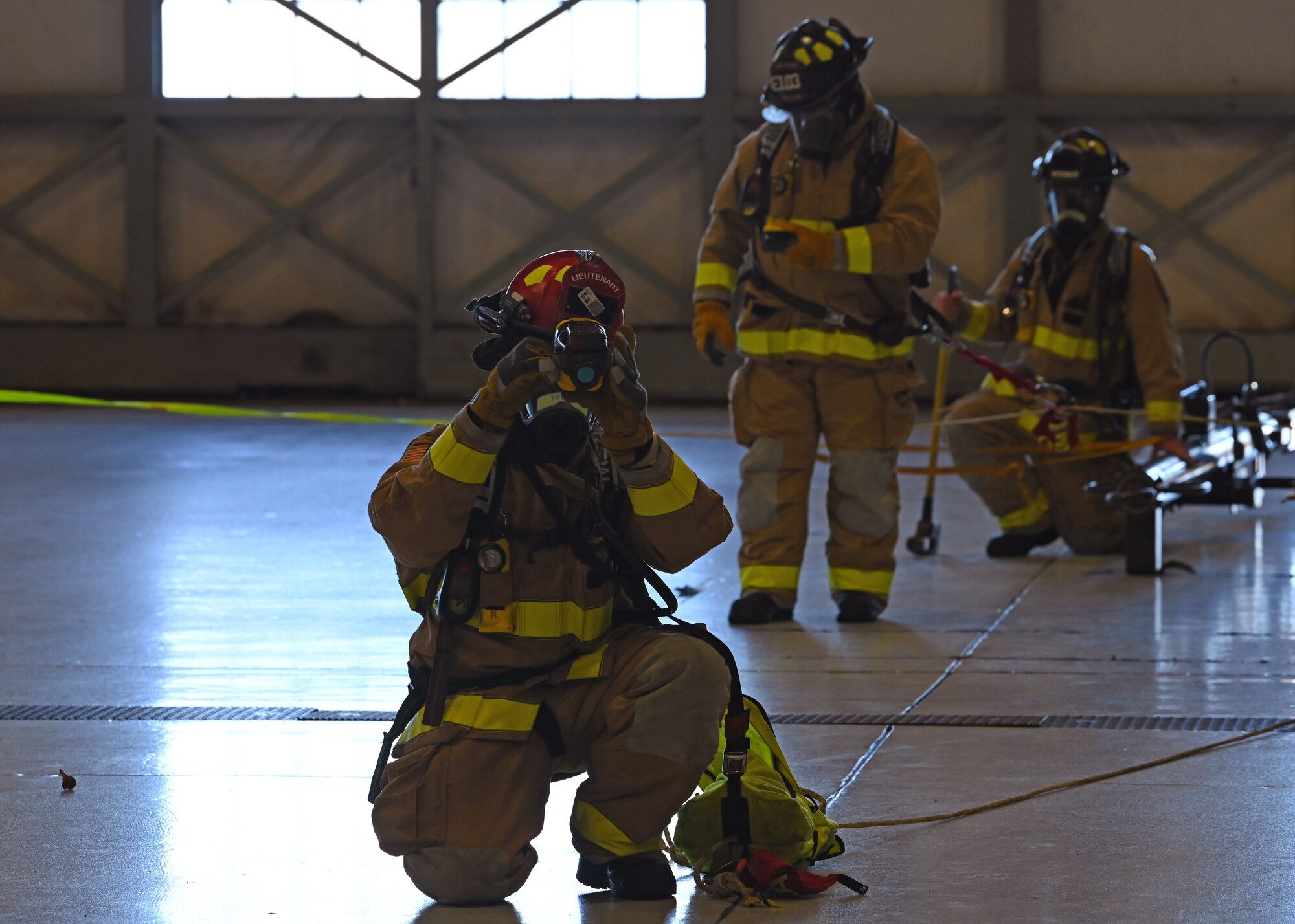 Lewis-McChord Fire and Emergency Services emergency responders participate in a simulated emergency at a hangar during Exercise Rainier War 21B at Joint Base Lewis-McChord, Washington, Nov. 8, 2021. Rainier War is a semi-annual, large readiness exercise led by 62nd Airlift Wing, designed to train Airmen under realistic scenarios that support a full spectrum readiness operations against modern threats and replicate today’s contingency operations. (U.S. Air Force photo by Senior Airman Zoe Thacker)