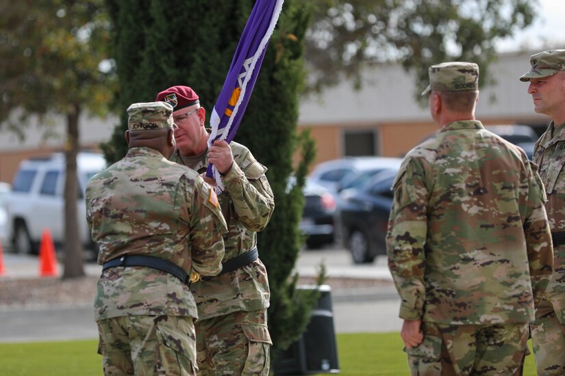 Maj. Gen. Jeffrey C. Coggin, commanding general, U.S. Army Civil Affairs and Psychological Operations Command (Airborne), receives the organizational colors of the 351st Civil Affairs Command from outgoing commander, Brig. Gen. Isaac Johnson, Jr., during the change of command ceremony at the Sgt. Witkowski Armed Forces Reserve Center, Mountain View, California, Saturday, Nov. 6, 2021.