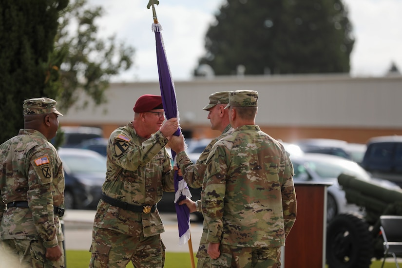 Maj. Gen. Jeffrey C. Coggin, commanding general, U.S. Army Civil Affairs and Psychological Operations Command (Airborne), hands the organizational colors of the 351st Civil Affairs Command to incoming commander, Brig. Gen. Christopher J. Dziubek, symbolizing the transfer of command authority, during the change of command ceremony at the Sgt. James Witkowski Armed Forces Reserve Center, Mountain View, California, Saturday, Nov. 6, 2021.