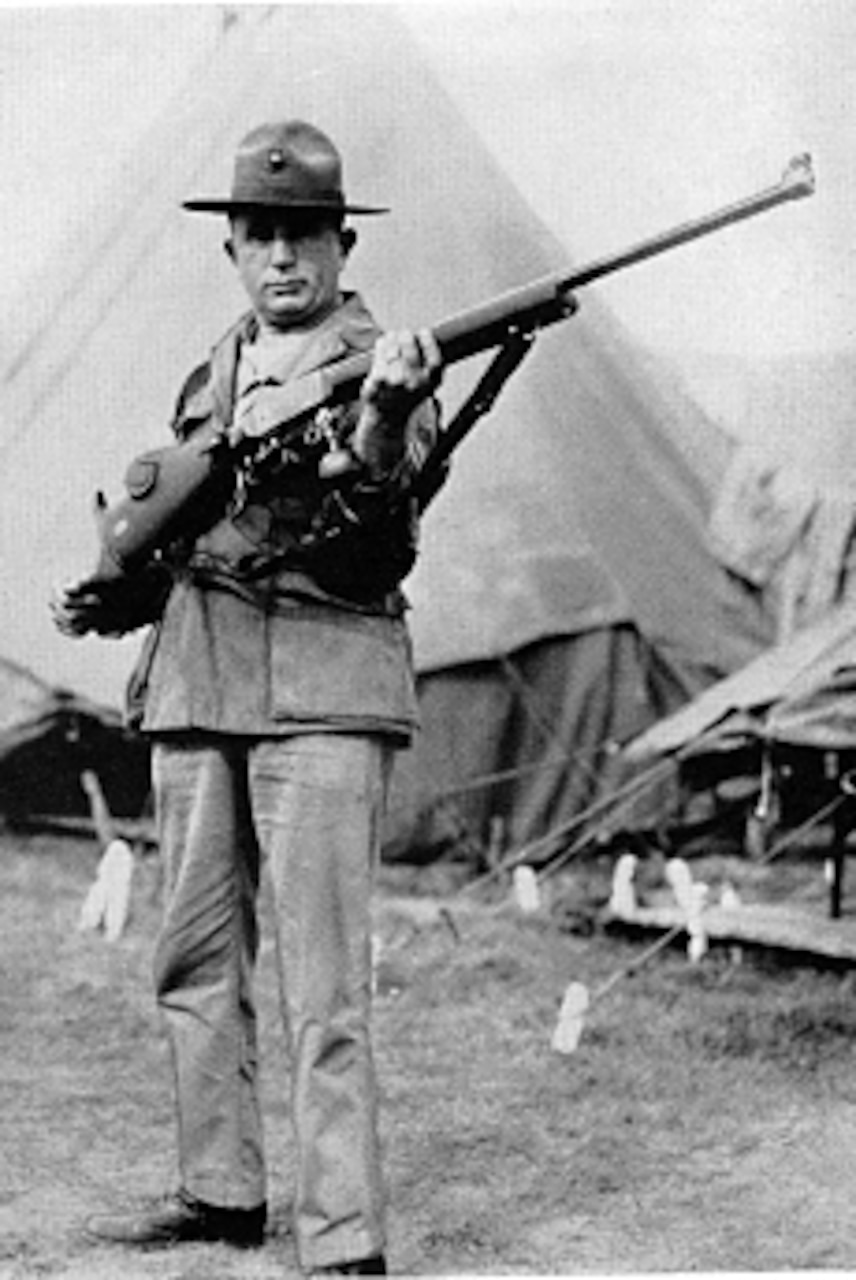 A Marine stands with a rifle.