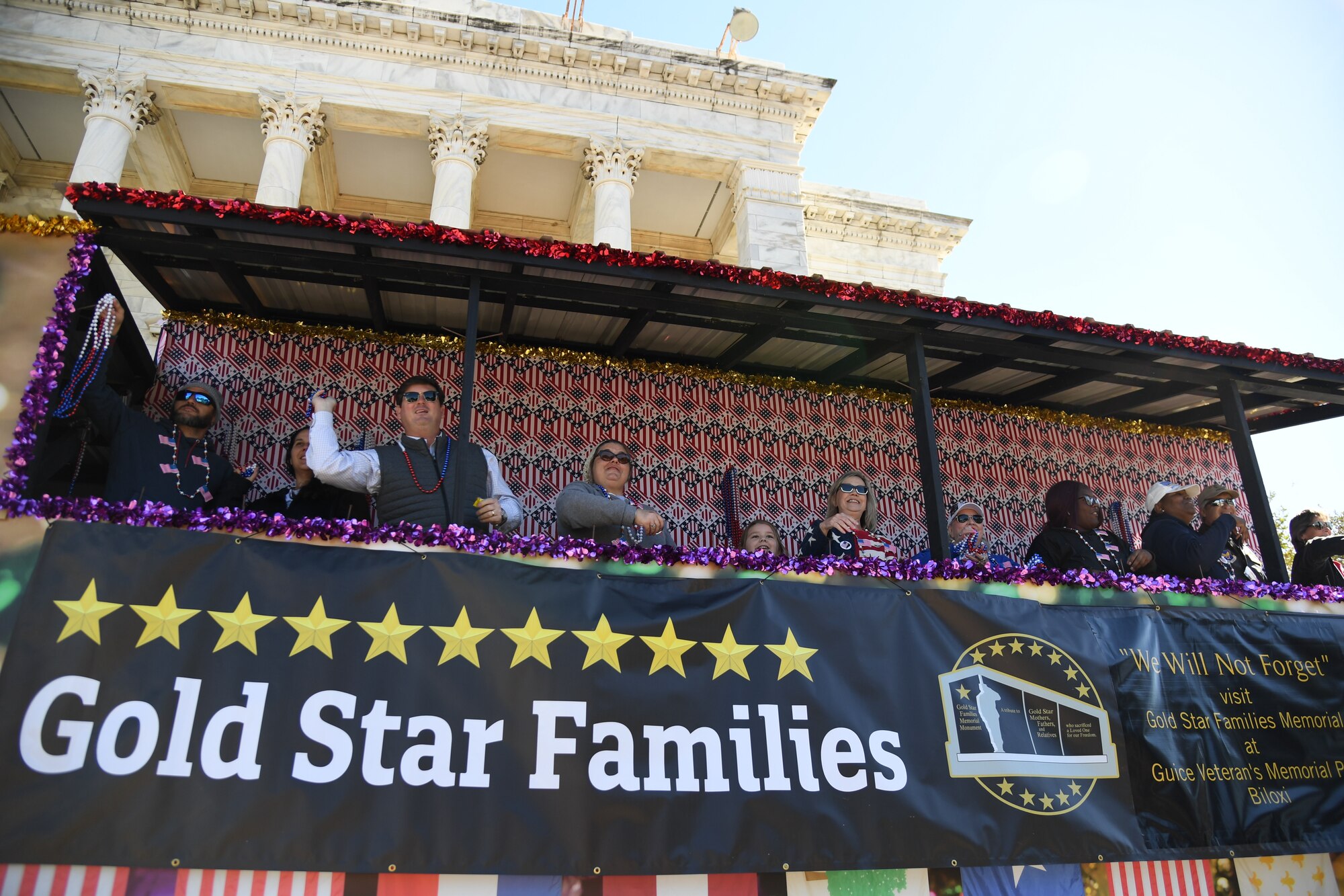 Members of Gold Star Families ride in a float during the 21st Annual Gulf Coast Veterans Day Parade in Biloxi, Mississippi, Nov. 6, 2021. Keesler Air Force Base leadership, along with hundreds of Airmen, attended and participated in the parade in support of all veterans, past and present. More than 50 unique floats, marching bands and military units marched in the largest Veterans Day parade on the Gulf Coast. (U.S. Air Force photo by Kemberly Groue)
