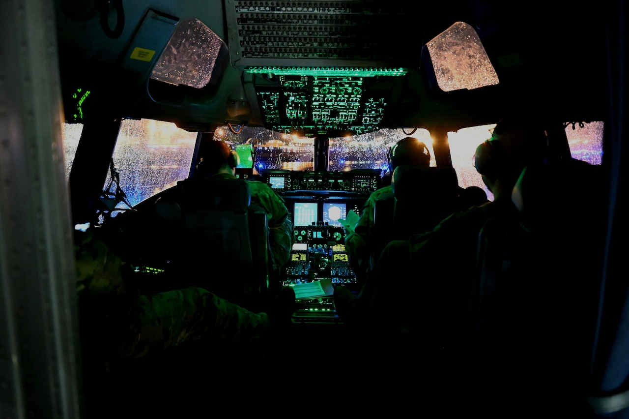 Two pilots sit in a cockpit of an aircraft.