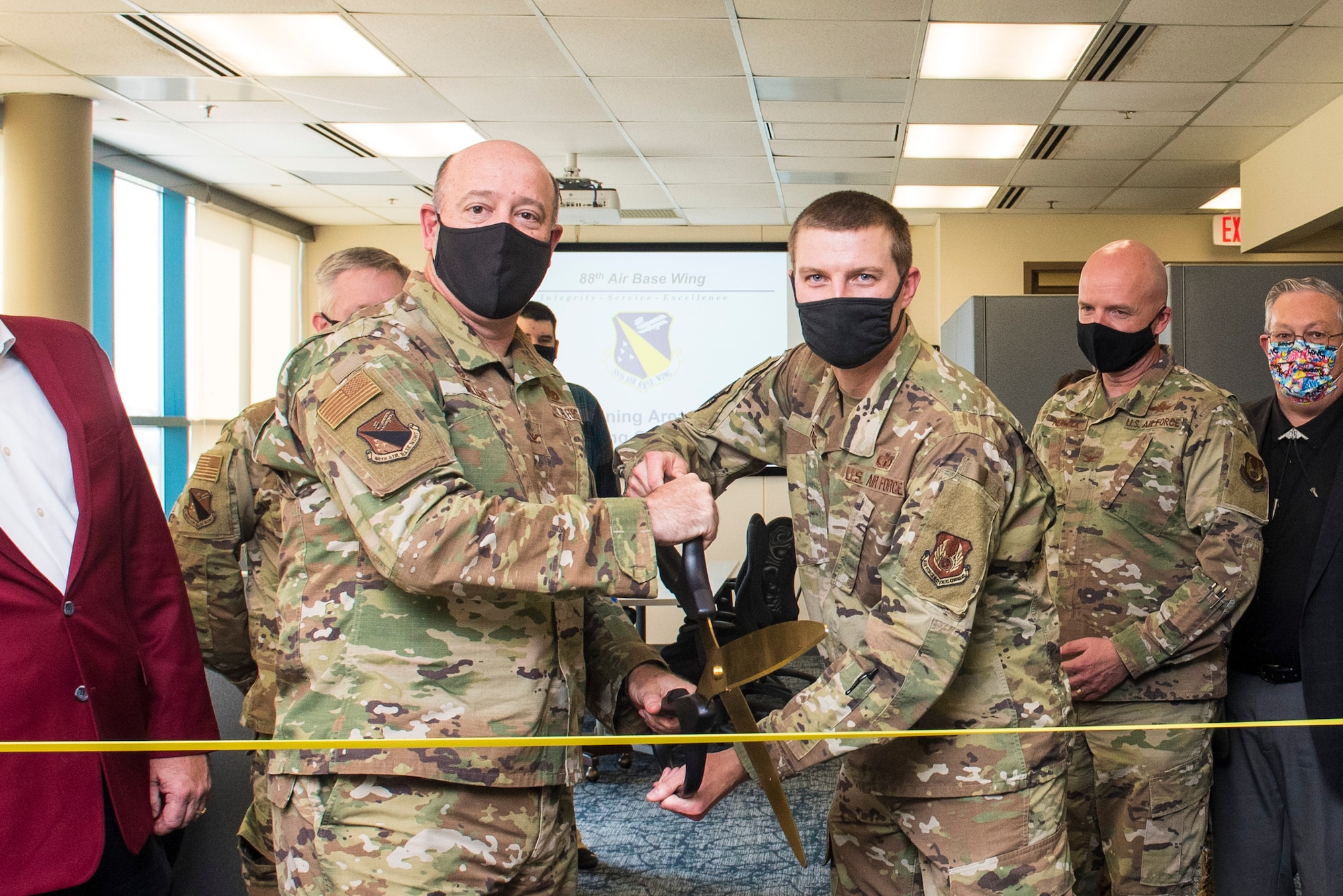 Col. Patrick Miller, 88th Air Base Wing commander, and Maj. Hollis Troxel, 88th Operations Support Squadron director of operations, cut a ribbon to commemorate the official opening of the 13M Follow-On Skills Training facility at Wright-Patterson Air Force Base, Nov. 3, 2021. Wright-Patt’s 13M training facility is the first of four to open nationwide in an effort by the Air Force to standardize and accelerate the program. (U.S. Air Force photo by Jaima Fogg)