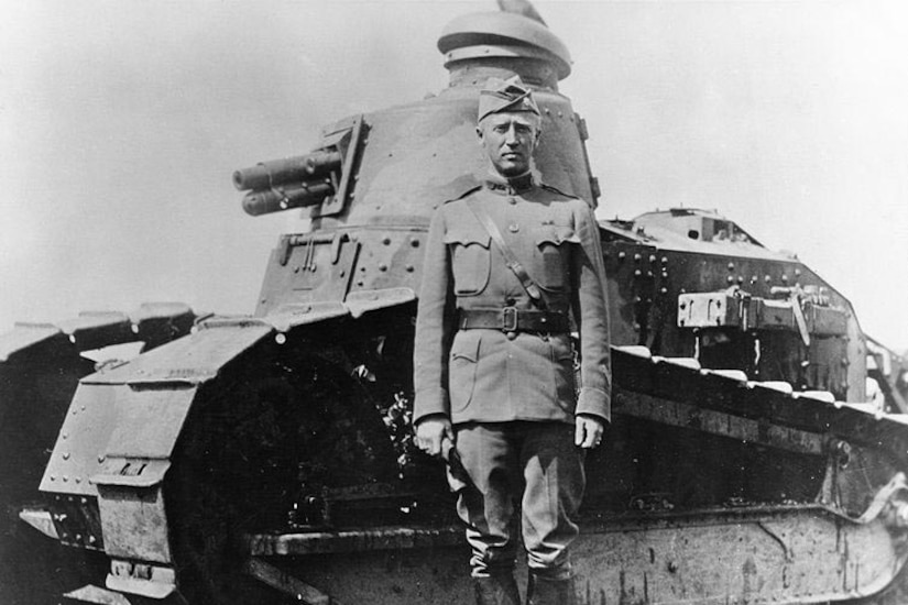 A man stands next to a tank.