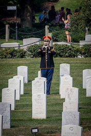 A U.S. Army Band bugler performs Taps during the burial of Army Cpl. Norvin D. Brockett at Arlington National Cemetery.
