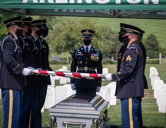 Arlington National Cemetery Casket Team members fold the flag during the burial of Army Cpl. Norvin D. Brockett on July 21, 2021.