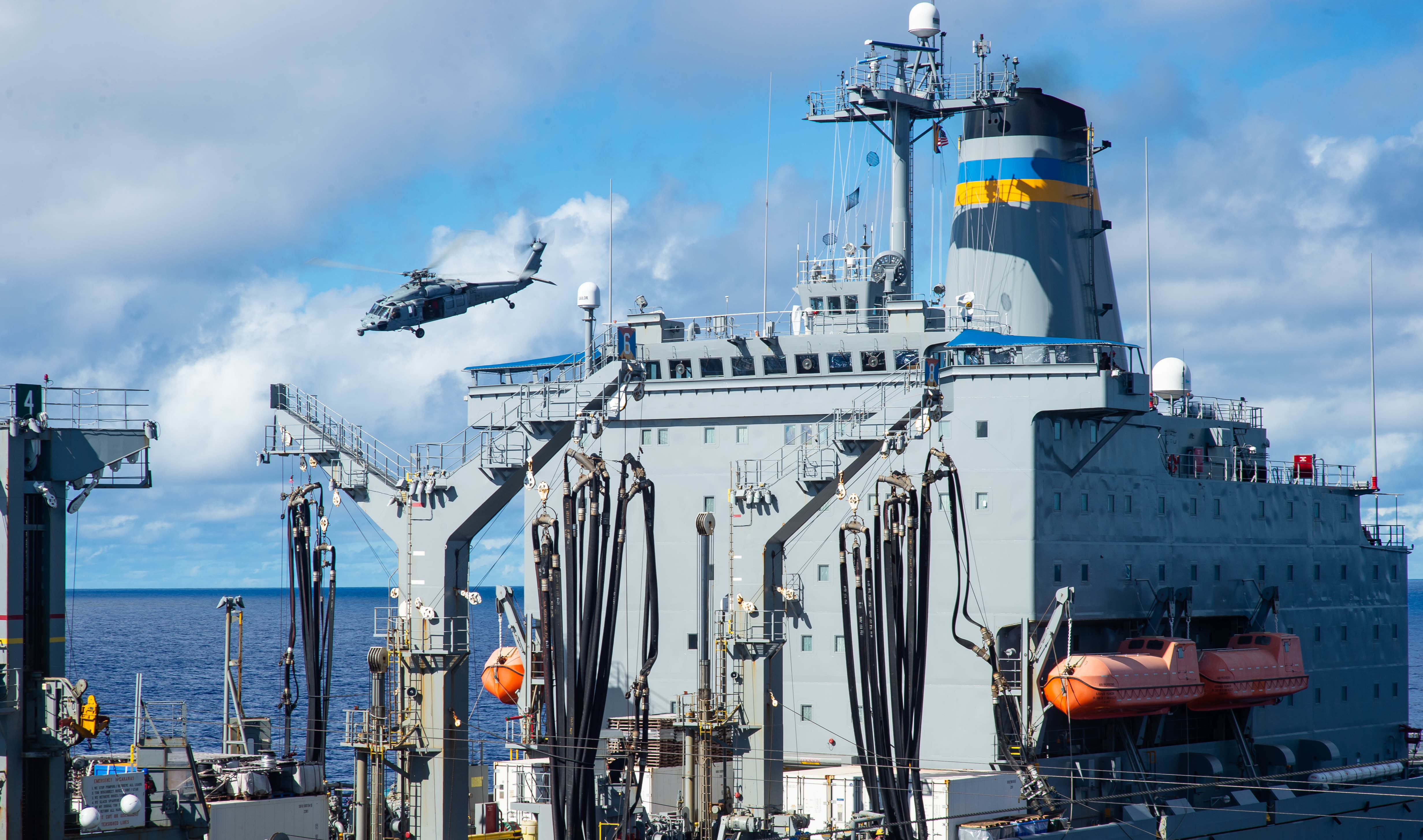 An MH-60S Sea Hawk, assigned to the "Island Knights" of Helicopter Sea Combat Squadron (HSC) 25, transports supplies to the Nimitz-class aircraft carrier USS Carl Vinson (CVN 70) during a vertical replenishment-at-sea with Henry J. Kaiser-class fleet replenishment oiler USNS Yukon (T-AO 202).
