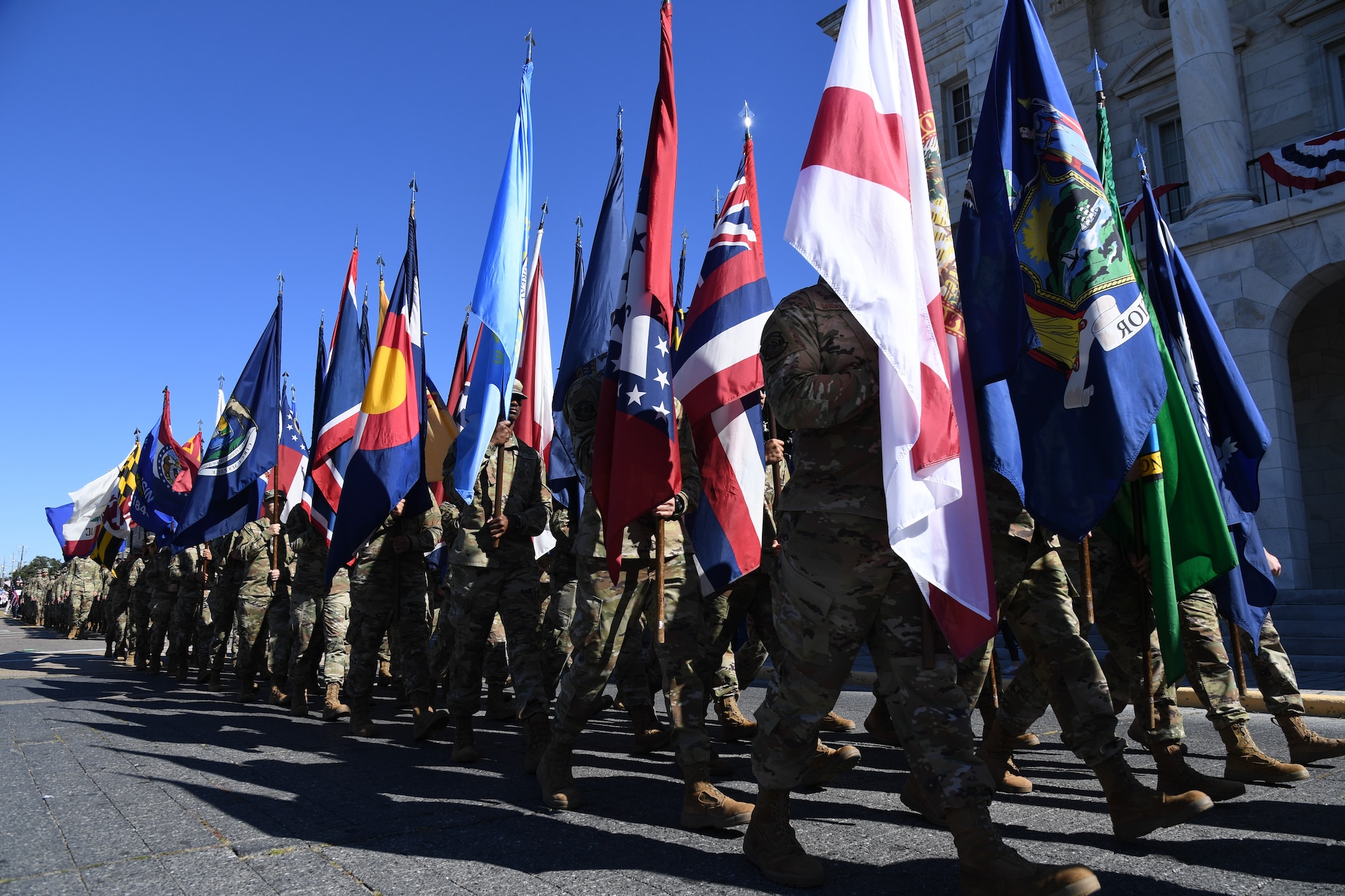 Airmen from the 81st Training Group carrying the 50 state flags march in the 21st Annual Gulf Coast Veterans Day Parade in Biloxi, Mississippi, Nov. 6, 2021. Keesler Air Force Base leadership, along with hundreds of Airmen, attended and participated in the parade in support of all veterans, past and present. More than 50 unique floats, marching bands and military units marched in the largest Veterans Day parade on the Gulf Coast. (U.S. Air Force photo by Kemberly Groue)
