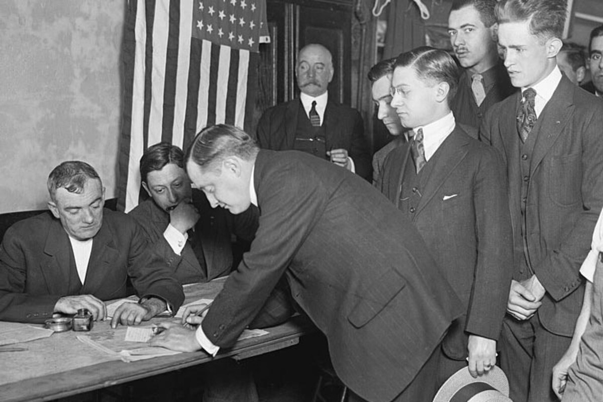 Men stand in a line next to a table.