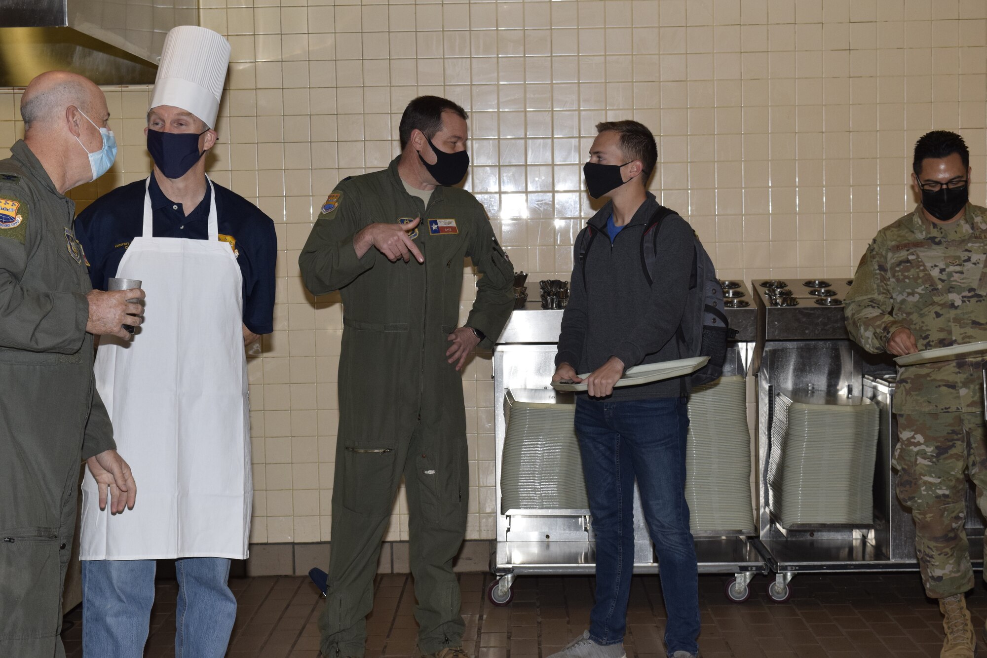 433rd Airlift Wing senior leaders and honorary commanders welcome military service members at the entry to the dining facility to the “Serve our Airmen” event at the Live Oak Dining Facility on Joint Base San Antonio-Lackland, Texas, Nov. 6, 2021. The 433rd AW Honorary Commanders Program bridges the local community and the military gap while creating a deeper understanding of military and Air Force traditions. (U.S. Air Force photo by Senior Airman Brittany Wich)