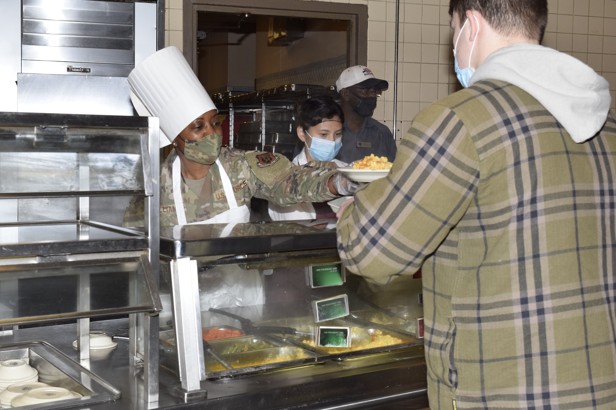 Chief Master Sgt. Takesha S. Williams, 433rd Airlift Wing command chief, serves a meal at the Live Oak Dining Facility on Joint Base San Antonio-Lackland, Texas, Nov. 6, 2021, during the “Serve our Airmen” event. The 433rd AW honorary commanders and senior leaders took shifts in serving meals and then ate lunch with service members. (U.S. Air Force photo by Senior Airman Brittany Wich)