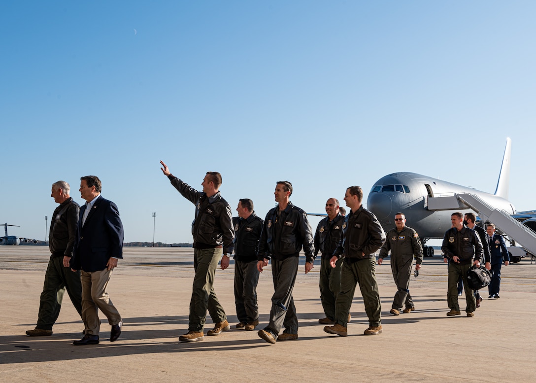A group of men walk away from the KC-46 while waving