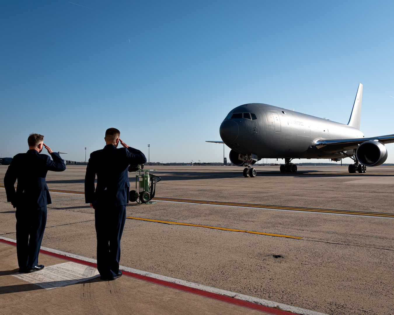 Two men salute the Kc-46