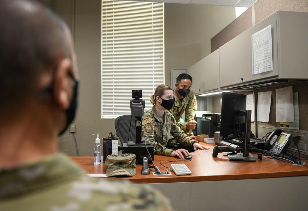U. S. Air Force Tech. Sgt. Bryan Tagaan, 802nd Force Support Squadron customer support NCO in charge, right, and Airman Roxana Horjescu customer support technician, center, create a Space Force ID card, Sept. 14, 2021, at Joint Base San Antonio-Randolph, Texas.