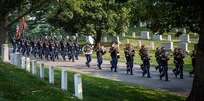 Members of the U.S. Army Band are followed by a military marching element during the transfer of Army Cpl. Norvin D. Brockett to his burial site at Arlington National Cemetery on July 21, 2021.