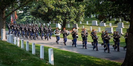 Members of the U.S. Army Band are followed by a military marching element during the transfer of Army Cpl. Norvin D. Brockett to his burial site at Arlington National Cemetery on July 21, 2021.