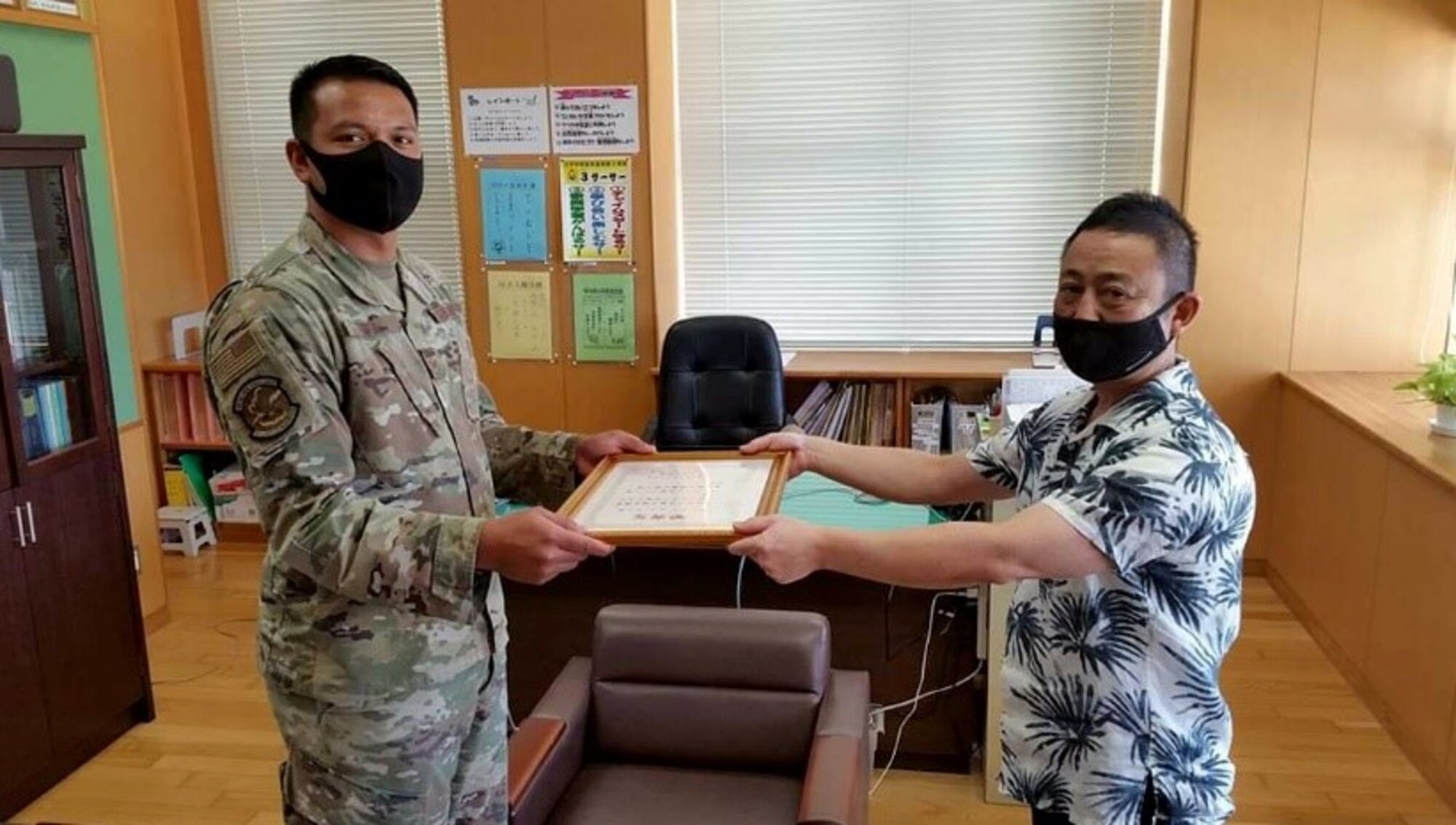 Two men hold a certificate.