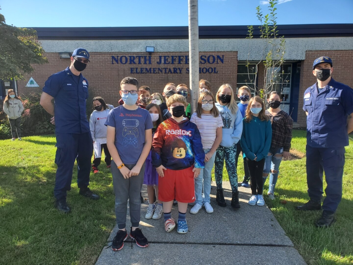 Petty Officer 1st Class Krystofer Murray (left) and Chief Petty Officer Jeston Whitacre, along with students of North Jefferson Elementary School in Kearneysville, West Virginia, stand by the school’s flagpole during flag training on Oct. 21. Murray and Whiteacre taught students the history of our nation’s flag and the importance of the traditional colors ceremony. Photo taken by Amy Dinges, North Jefferson Elementary School teacher.