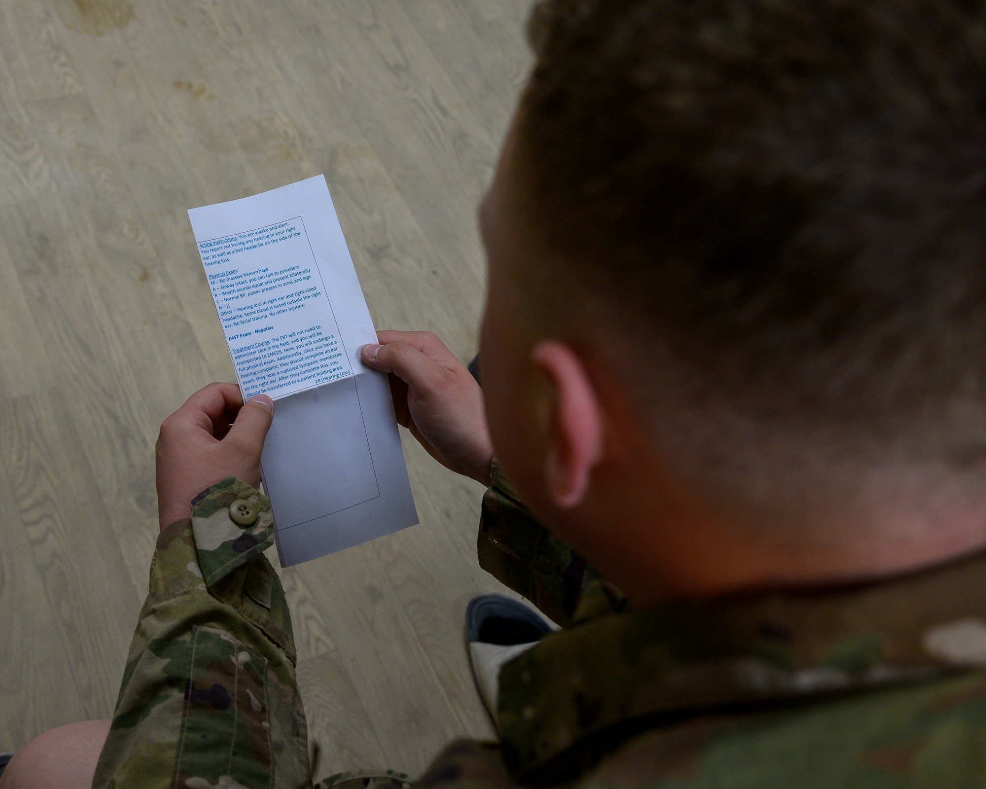 U.S. Air Force Senior Airman Jonathan Gavin, 378th Air Expeditionary Wing Finance Office customer service technician, reads over his mock casualty card during a mass casualty and missile defense exercise at Prince Sultan Air Base, Kingdom of Saudi Arabia, Oct. 28 2021.