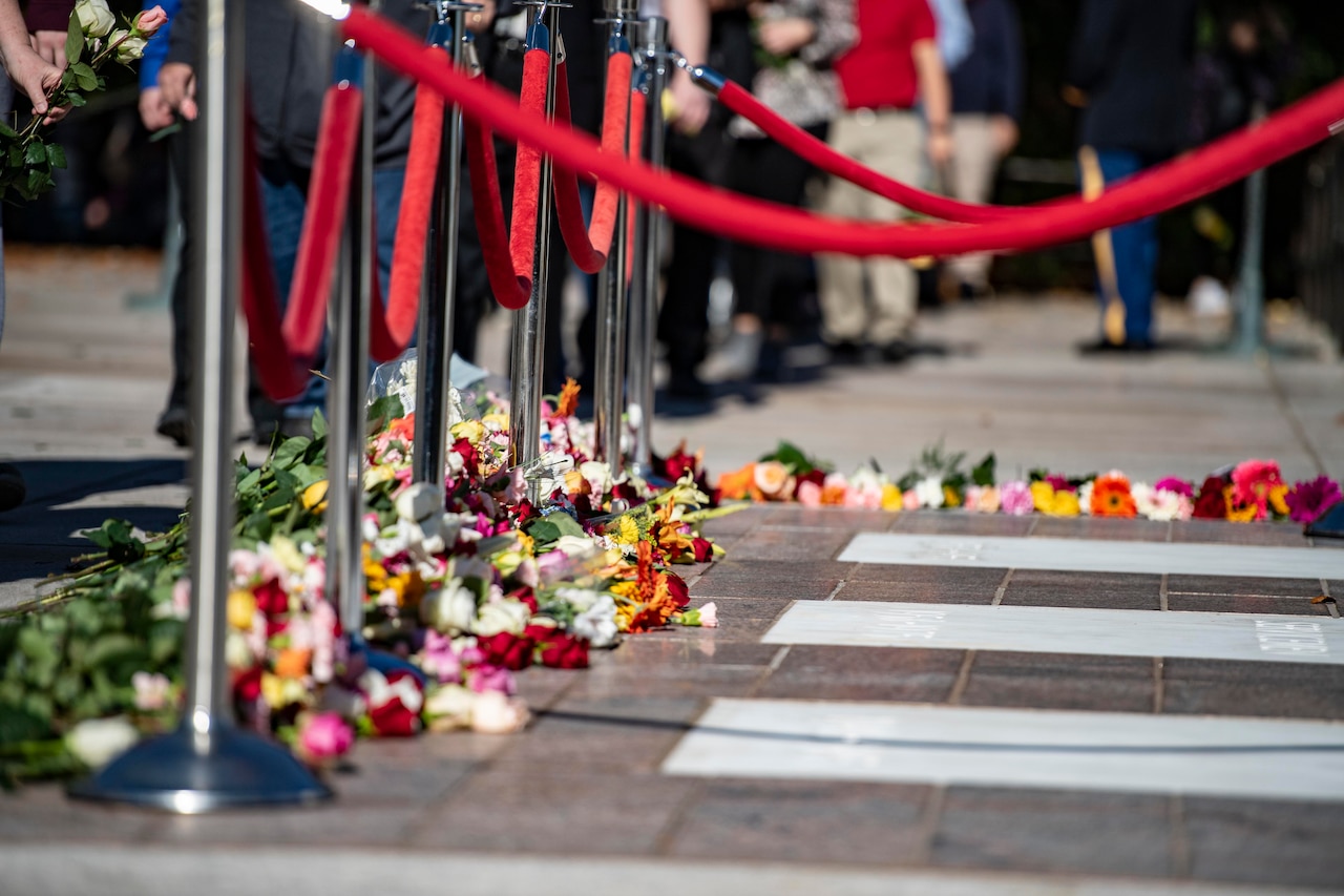 PIles of flowers on the ground in front of Tomb of the Unknown Soldier crypts.