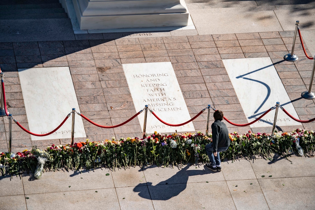 Overhead view of a child placing flowers at the Tomb of the Unknown Soldier.