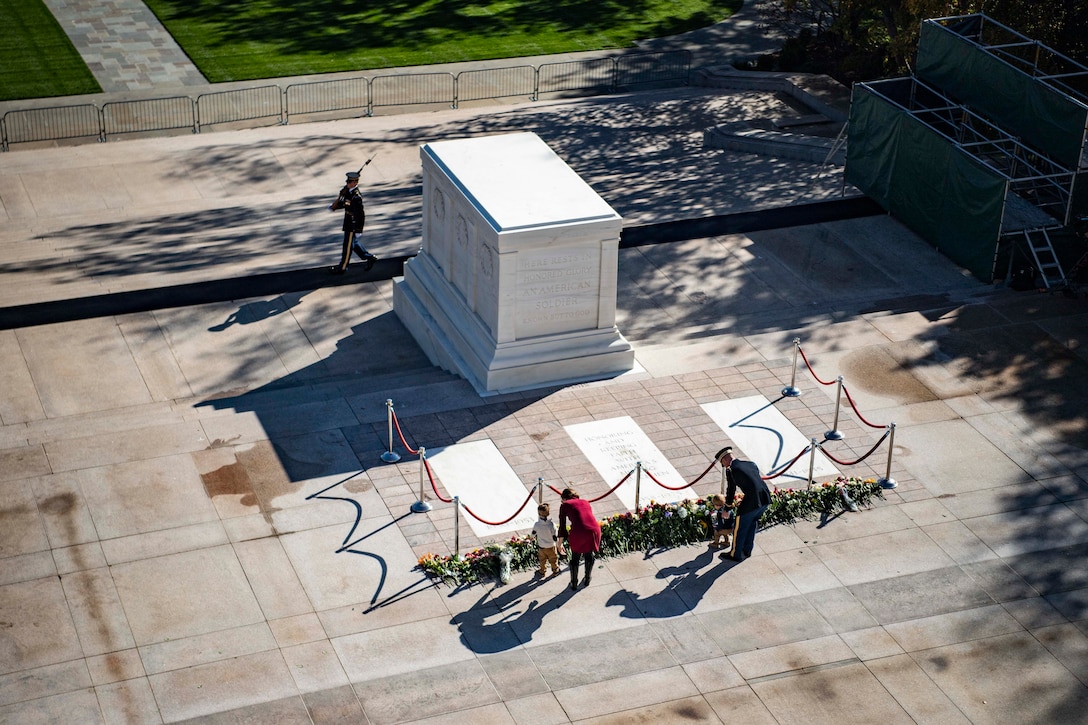 Overhead view of people laying flowers at Tomb of the Unknown Soldier while sentinel walks mat.