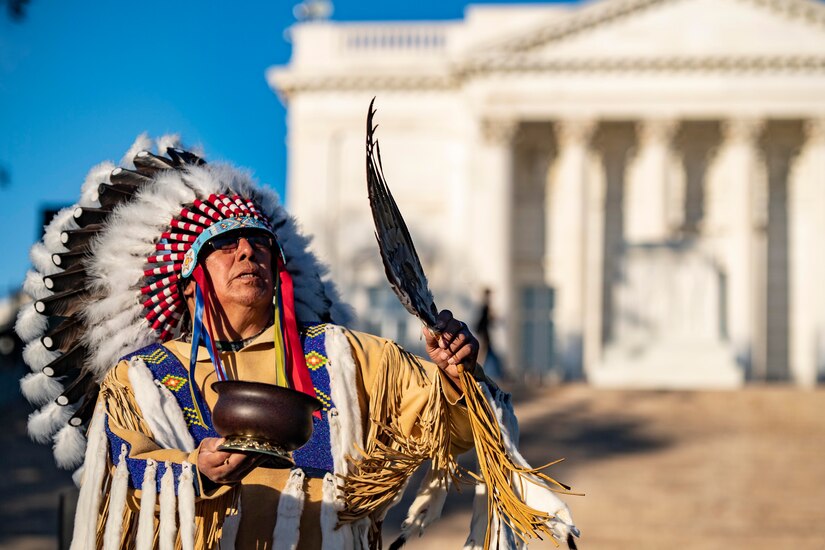 A Native American holds a smudge pot.