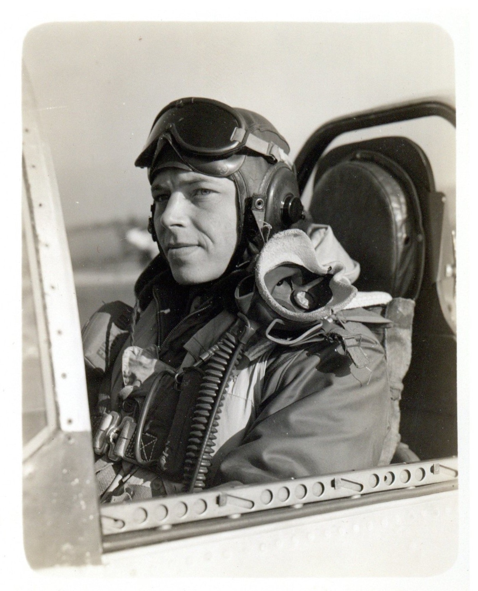 Pilot poses for a photo sitting in an aircraft.