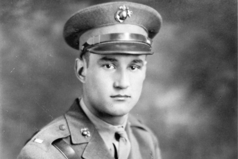 A man in uniform and service cap poses for a photo.