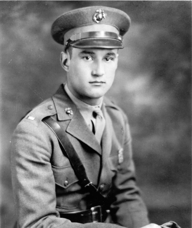 A man in uniform and service cap poses for a photo.