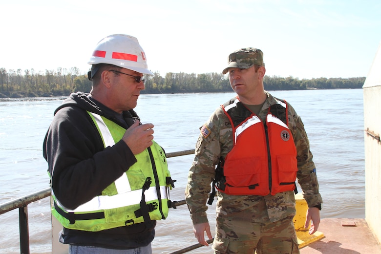Jake Bernhardt, Chief of Physical Support for the Dredge Goetz, explains the operations of the dredge to Maj. John Chambers, deputy commander for the Kansas City District, on the bow of the Dredge Goetz near St. Charles, Mo. on the Missouri River November 3, 2021.
