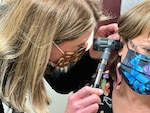Danielle Craft, family nurse practitioner at Bayne-Jones Army Community Hospital performs routine ear exam on Angela Bridges Nov. 8.